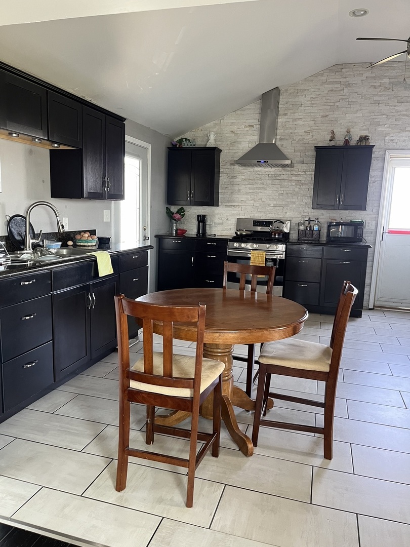 67 North 37th Road Mendota, IL 61342 - Photo 6 of 19 a kitchen with stainless steel appliances kitchen island granite countertop a sink a stove a table and chairs