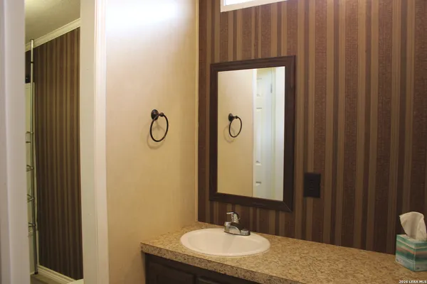a bathroom with a granite countertop sink and a mirror