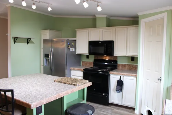 a kitchen with a kitchen island a stove a refrigerator and a sink