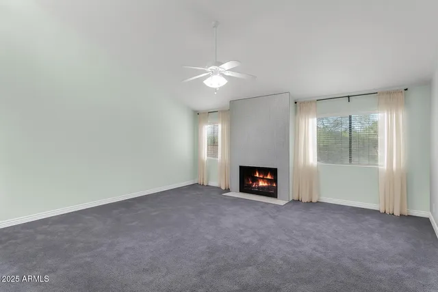 an empty room with a chandelier fan and closet area