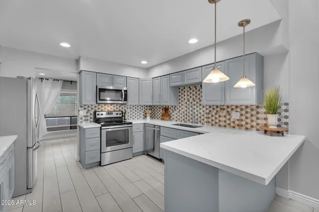 a kitchen with cabinets stainless steel appliances and a counter space