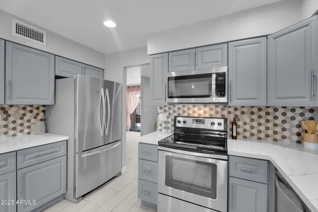 a kitchen with granite countertop a stove a sink and a microwave