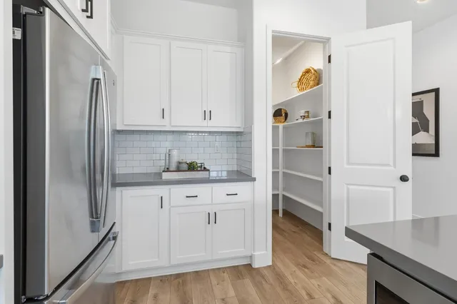 a bedroom with a large bed a chandelier and dresser