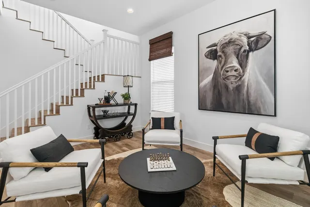 a kitchen with stainless steel appliances kitchen island granite countertop a dining table chairs and white cabinets