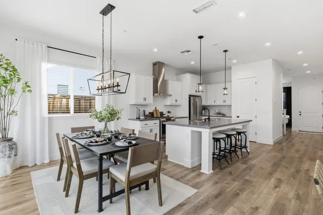 a dining room with furniture a chandelier and wooden floor