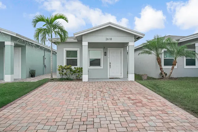 a front view of a house with a yard and potted plants