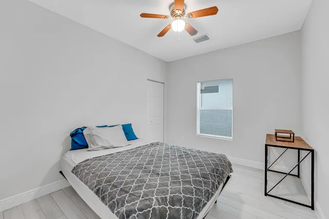 a bedroom with a bed and wooden floor