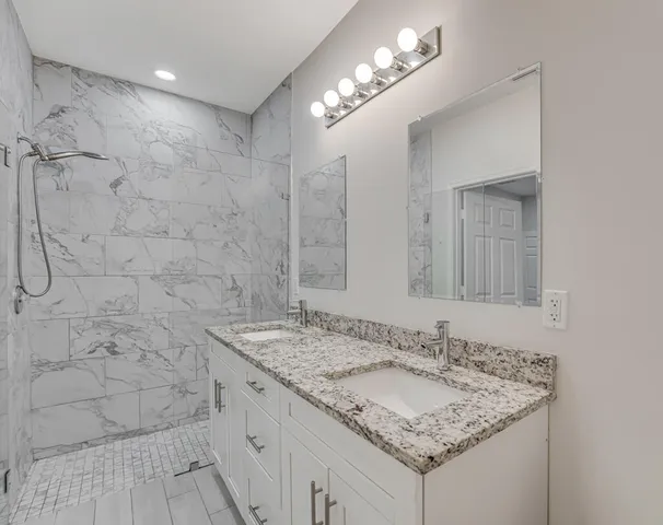 a bathroom with a granite countertop sink a toilet and a mirror