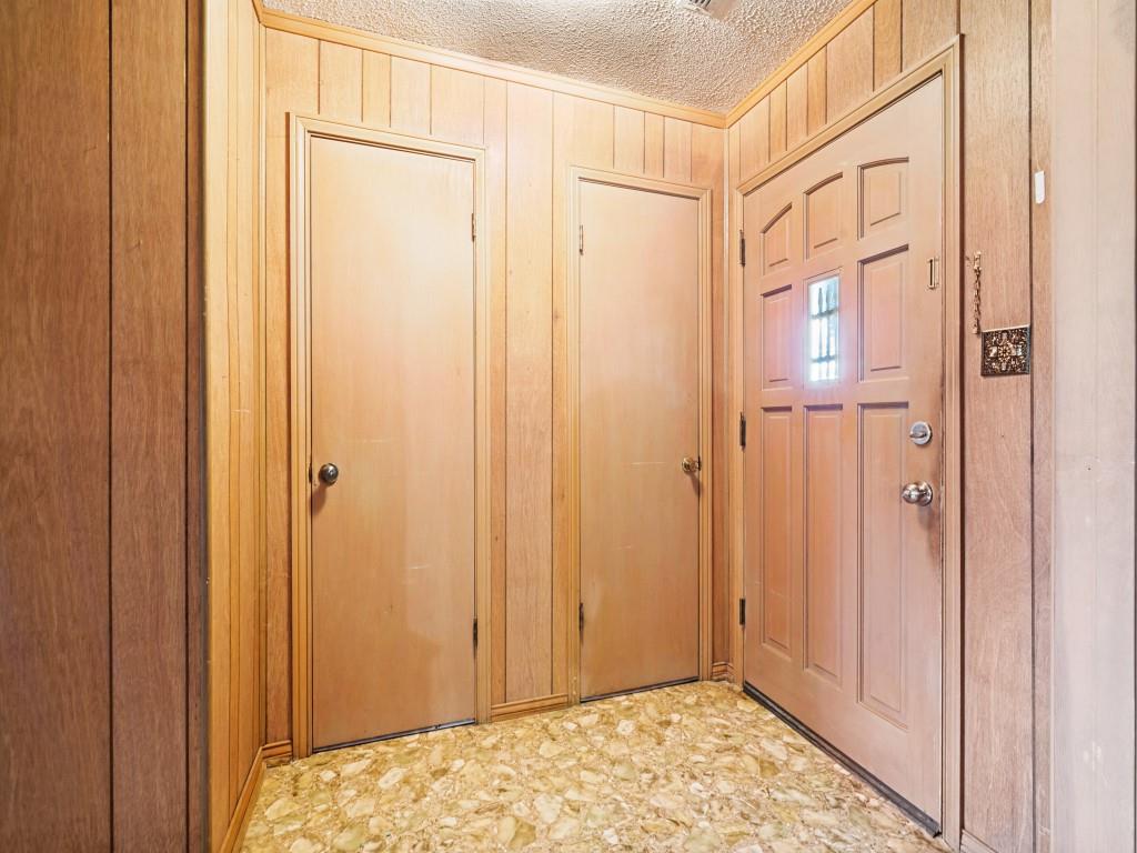 1081 Wright Street Terrell, TX 75160 - Photo 6 of 29 Entryway featuring wood paneling throughout, two flush doors, a paneled exterior door with a gridded window, and patterned tile flooring