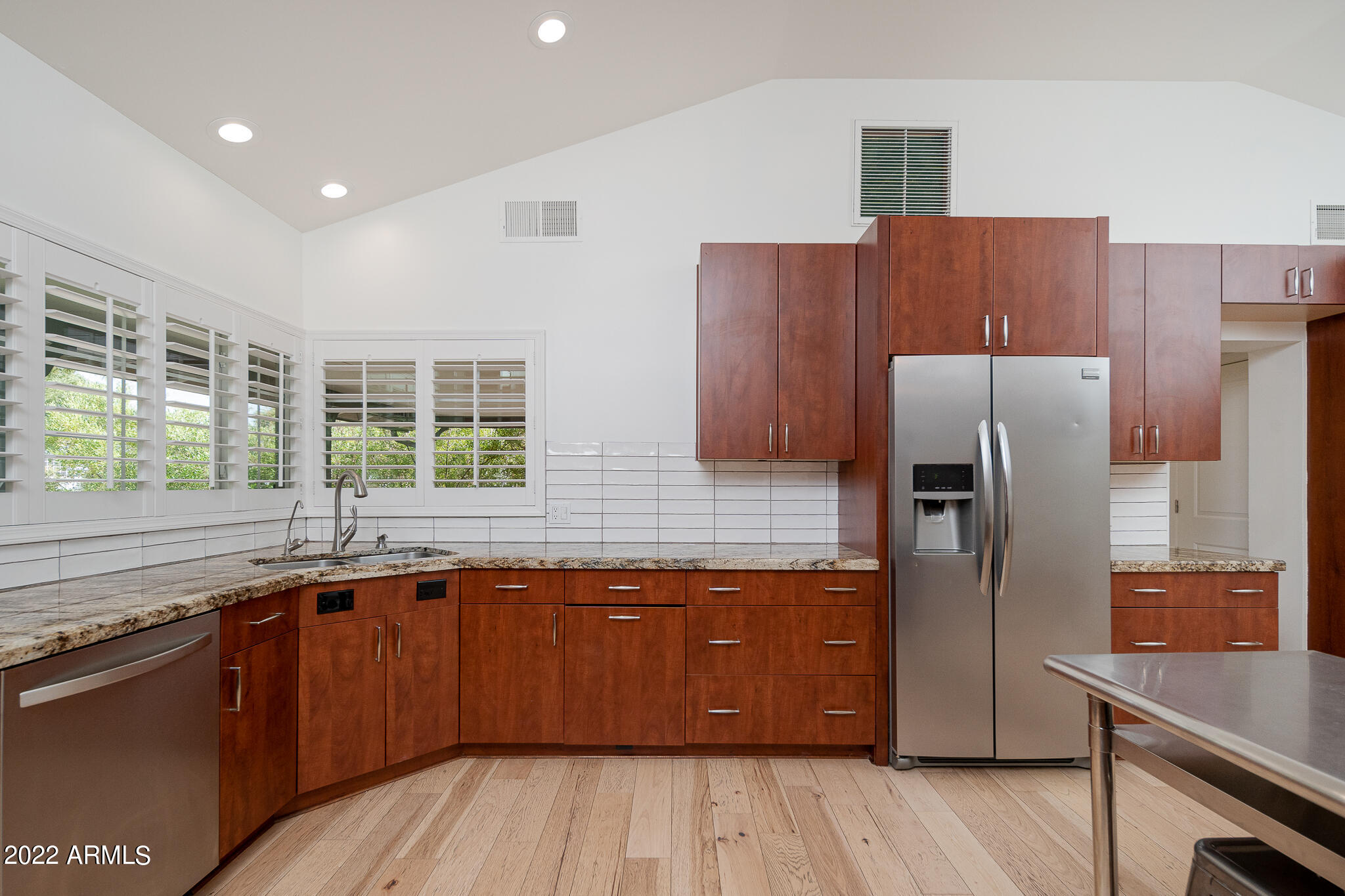 3864 North 50th Street Phoenix, AZ 85018 - Photo 15 of 15 a kitchen with stainless steel appliances granite countertop a sink a refrigerator and wooden cabinets