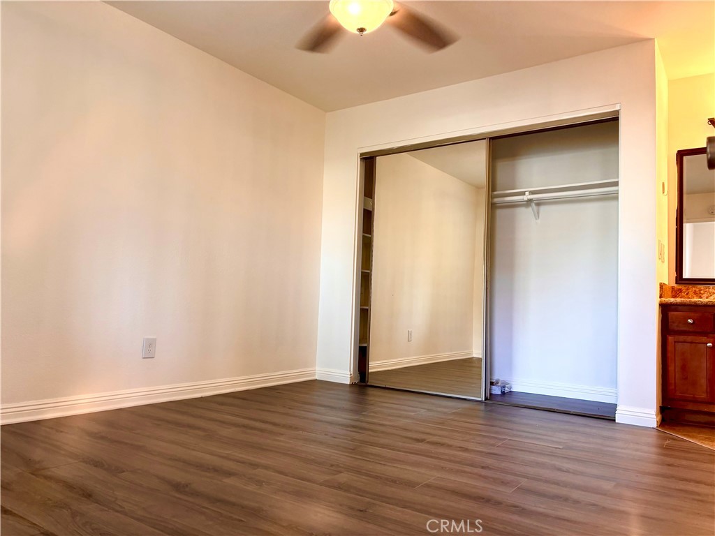 1110 West Blaine Street, Unit 102 Riverside, CA 92507 - Photo 15 of 25 an empty room with wooden floor and a ceiling fan