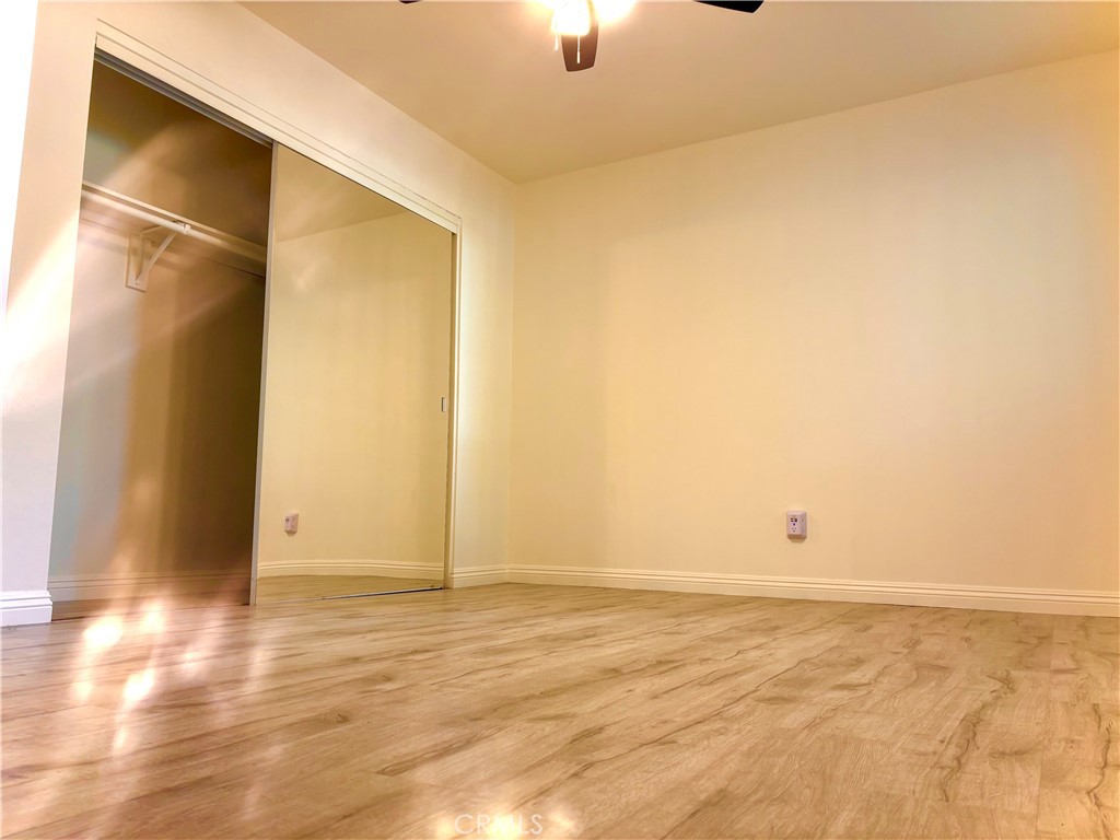 1110 West Blaine Street, Unit 102 Riverside, CA 92507 - Photo 16 of 25 an empty room with wooden floor and windows