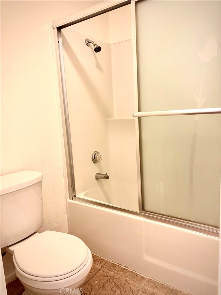 1110 West Blaine Street, Unit 102 Riverside, CA 92507 - Photo 9 of 25 a white toilet sitting next to a bath tub and a shower
