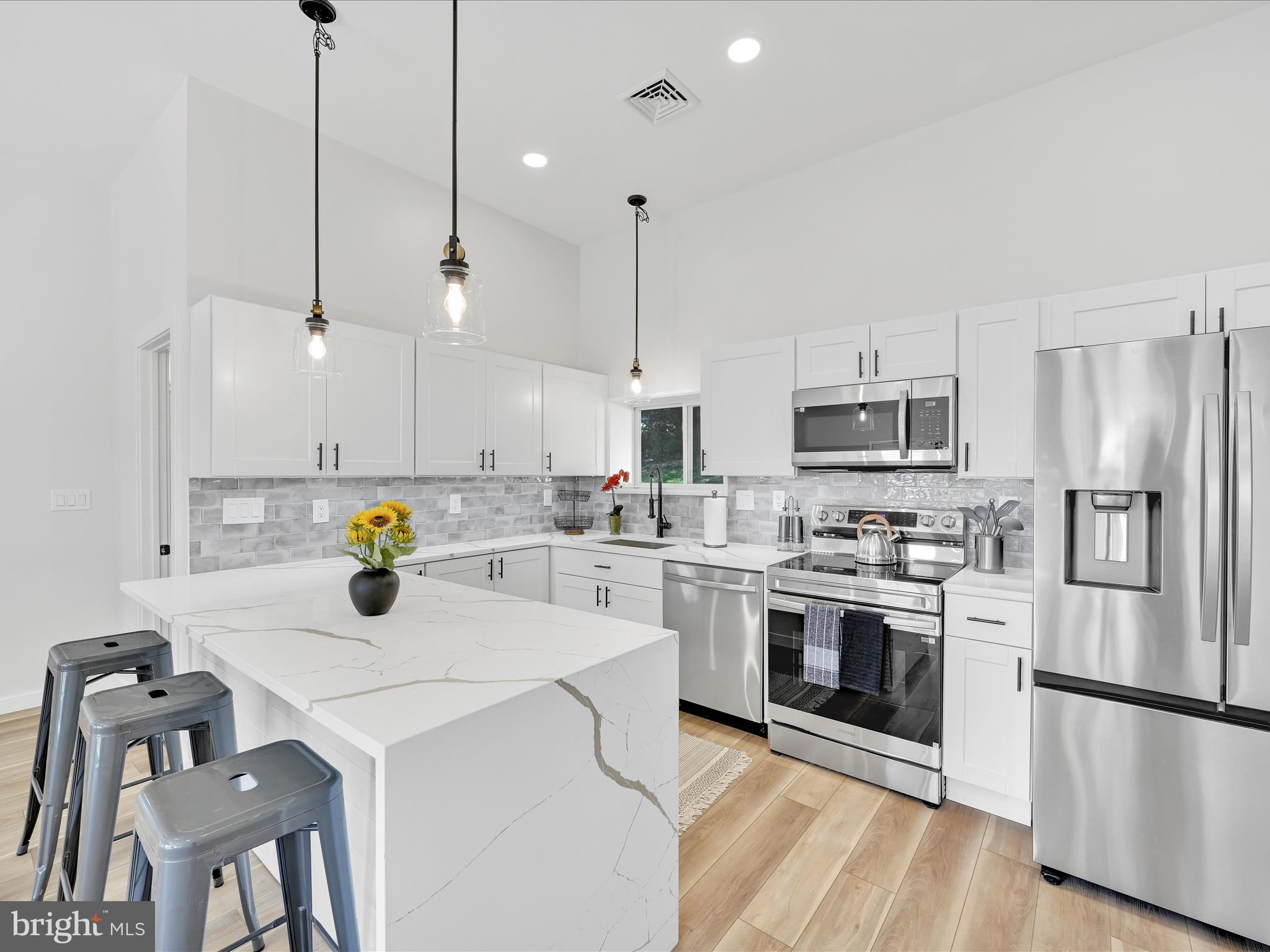 1056 West Leesport Road Leesport, PA 19533 - Photo 3 of 30 a kitchen with stainless steel appliances a stove a sink a refrigerator a center island and chairs