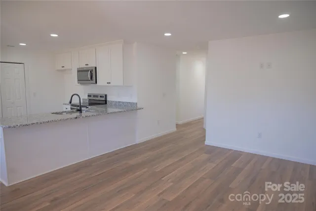 a view of a kitchen with a sink and wooden floor