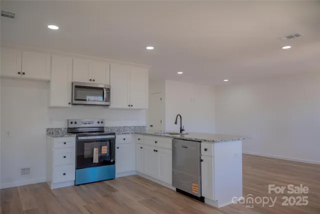 a kitchen with a sink cabinets and wooden floor