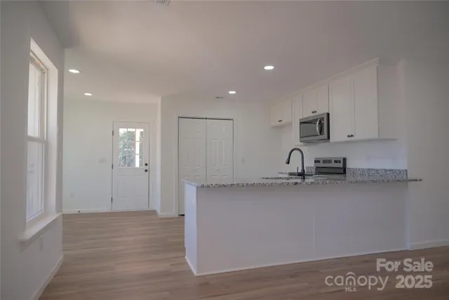 a kitchen with stainless steel appliances granite countertop a sink a stove and a refrigerator