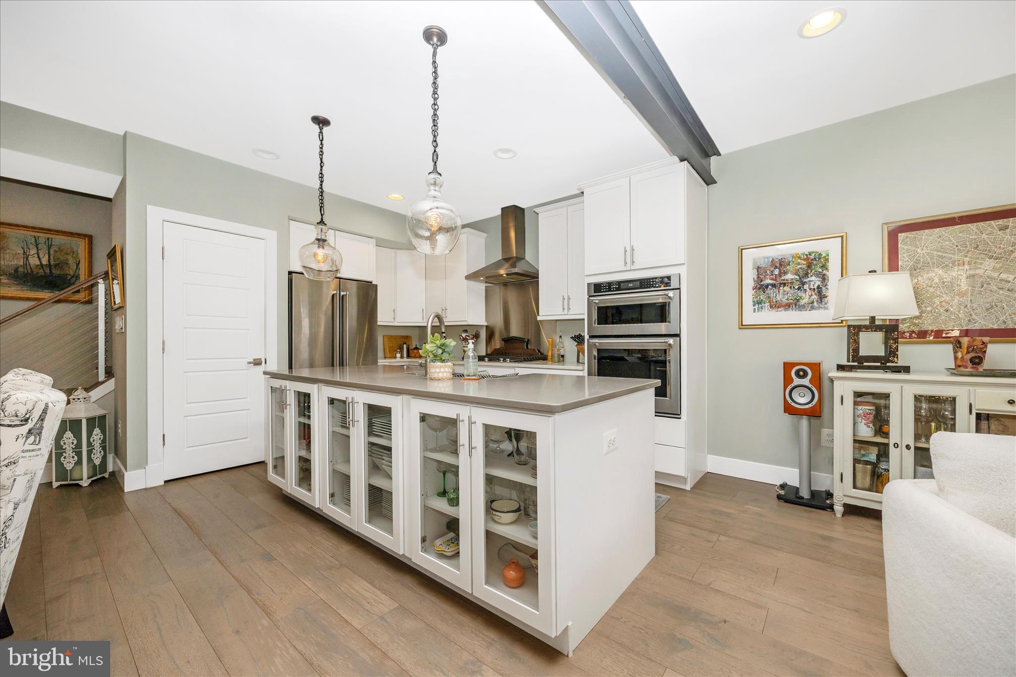 8 1/2 West 5th Street Frederick, MD 21701 - Photo 19 of 62 a kitchen with stainless steel appliances a stove top oven a sink a refrigerator white cabinets and wooden floor
