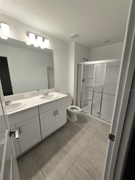 3575 Mayfair Street Kissimmee, FL 34758 - Photo 14 of 34 a bathroom with a double vanity sink a toilet and a mirror