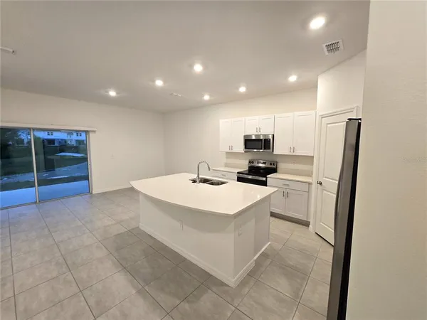 a view of kitchen with refrigerator sink and wooden floor
