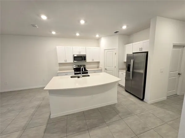 a view of kitchen with stainless steel appliances a refrigerator and a sink