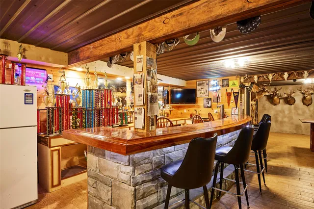 a living room with stainless steel appliances kitchen island granite countertop a sink and cabinets