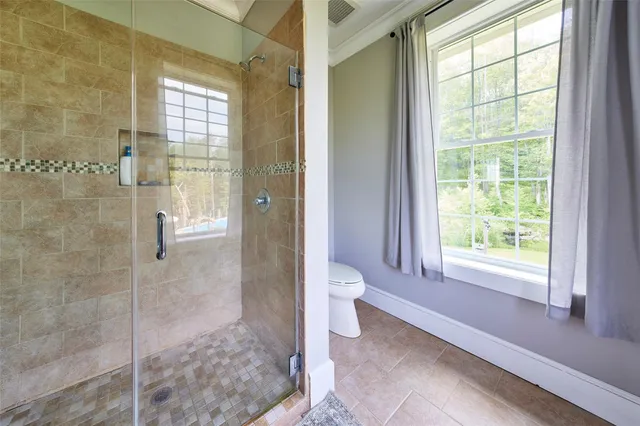 a bedroom with a bed and a flat tv screen on dresser