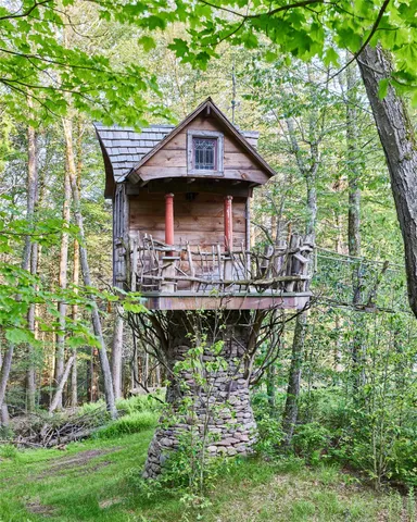 a view of a big house with a big yard and large trees