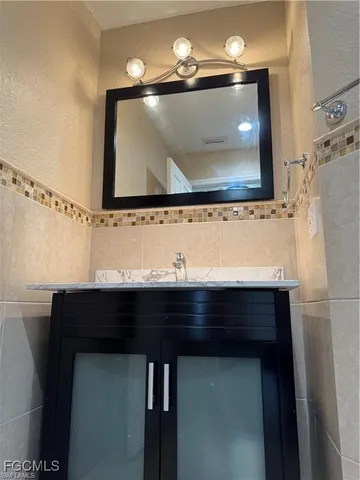 a bathroom with a sink a mirror and a vanity