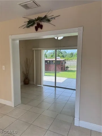 an empty room with fan and a floor to ceiling window