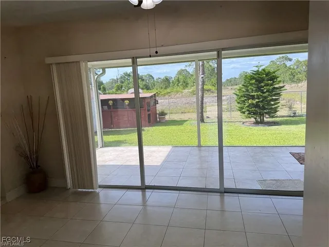 a view of an empty room with floor to ceiling windows with wooden floor