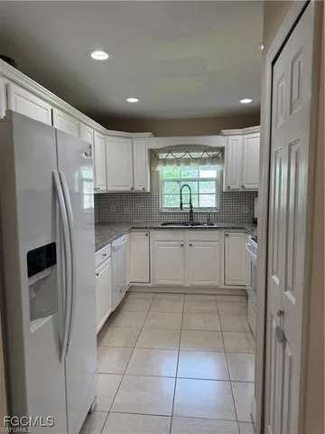 a kitchen with stainless steel appliances granite countertop a refrigerator sink and cabinets