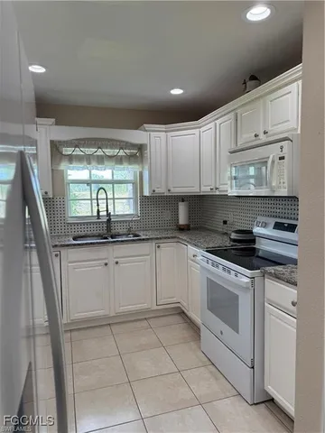 a kitchen with a stove sink and cabinets