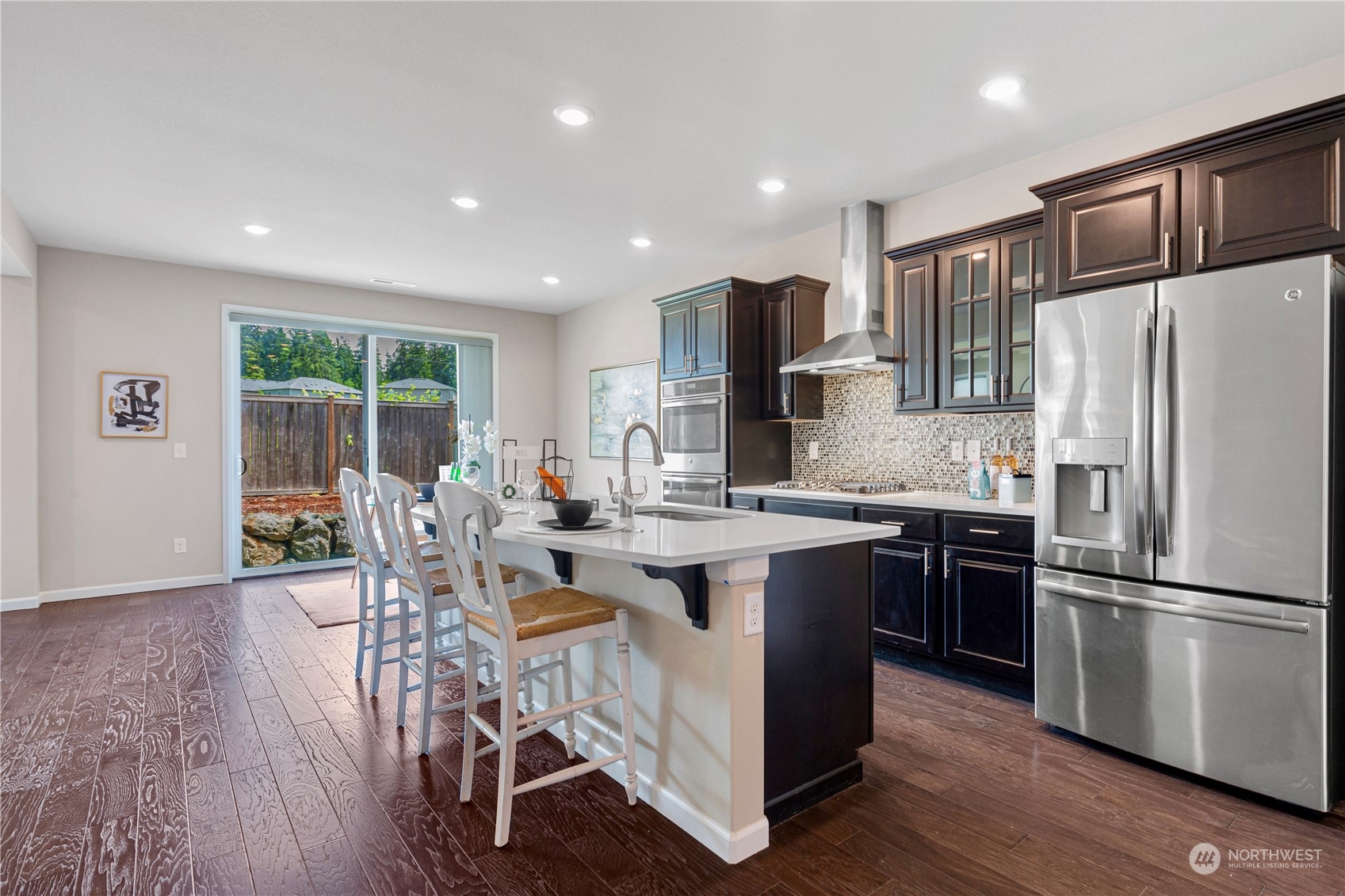 21311 42nd Avenue Southeast Bothell, WA 98021 - Photo 5 of 24 a kitchen with stainless steel appliances granite countertop a refrigerator a stove a sink a dining table and chairs