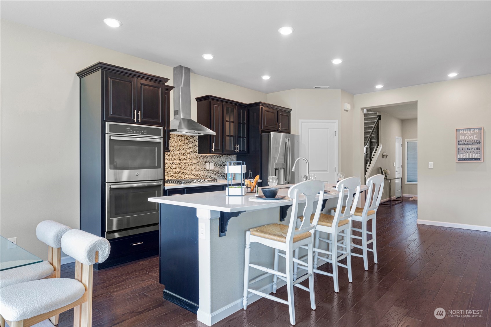 21311 42nd Avenue Southeast Bothell, WA 98021 - Photo 6 of 24 a kitchen with stainless steel appliances kitchen island granite countertop a table chairs sink and cabinets