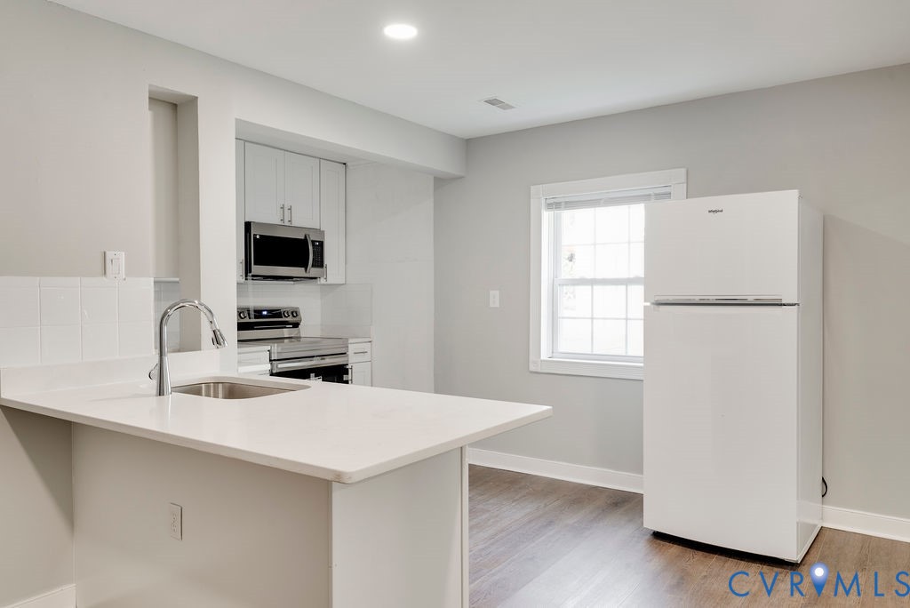 8510 Hunton Circle North Chesterfield, VA 23235 - Photo 17 of 32 a kitchen with a sink a refrigerator and a stove top oven