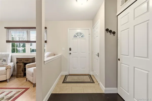 a view of an entryway with wooden floor and a livingroom