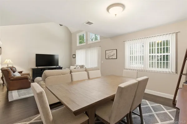 a living room with furniture a flat screen tv and a large window