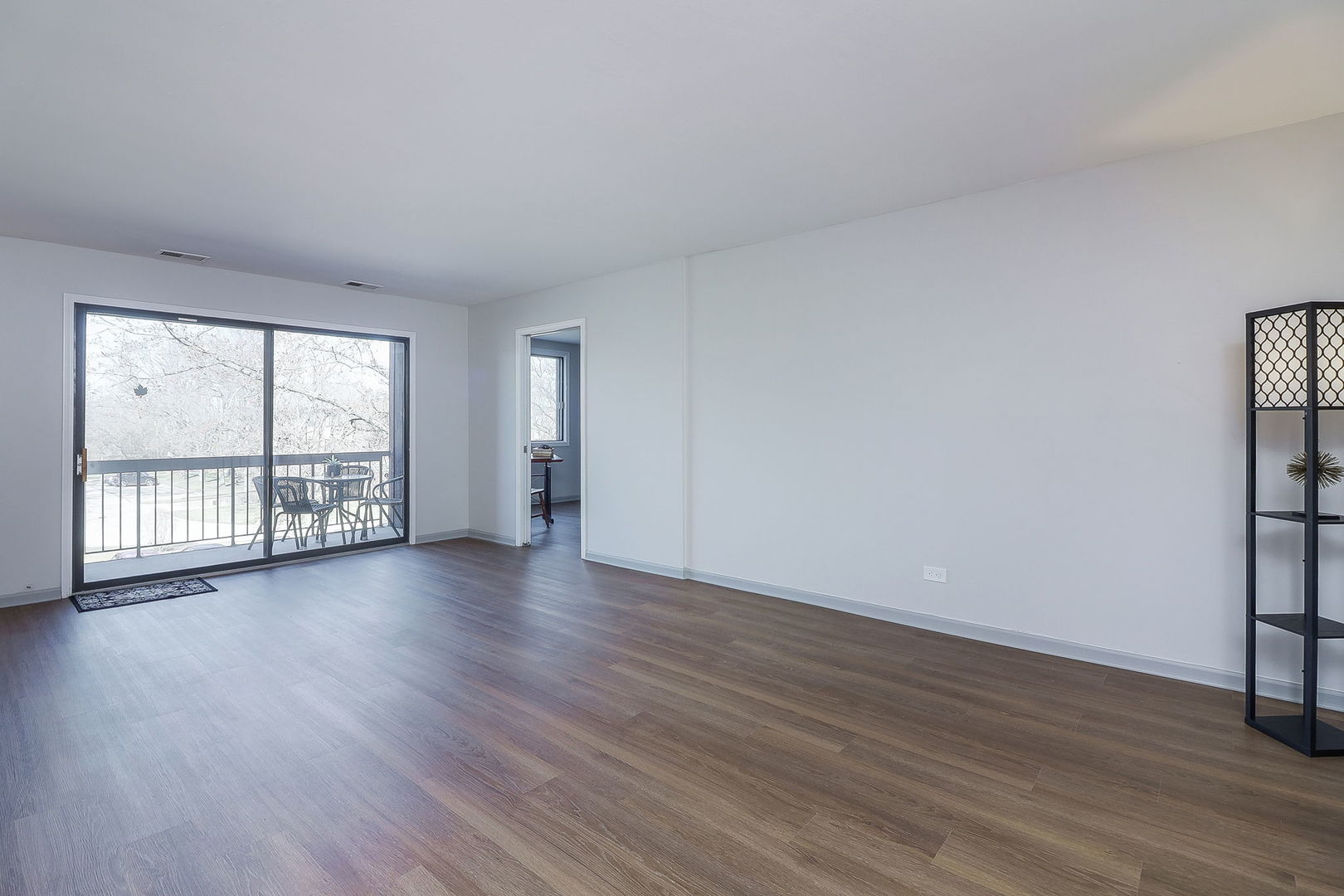 440 Raintree Court, Unit 2D Glen Ellyn, IL 60137 - Photo 3 of 23 a view of an empty room with wooden floor and a window