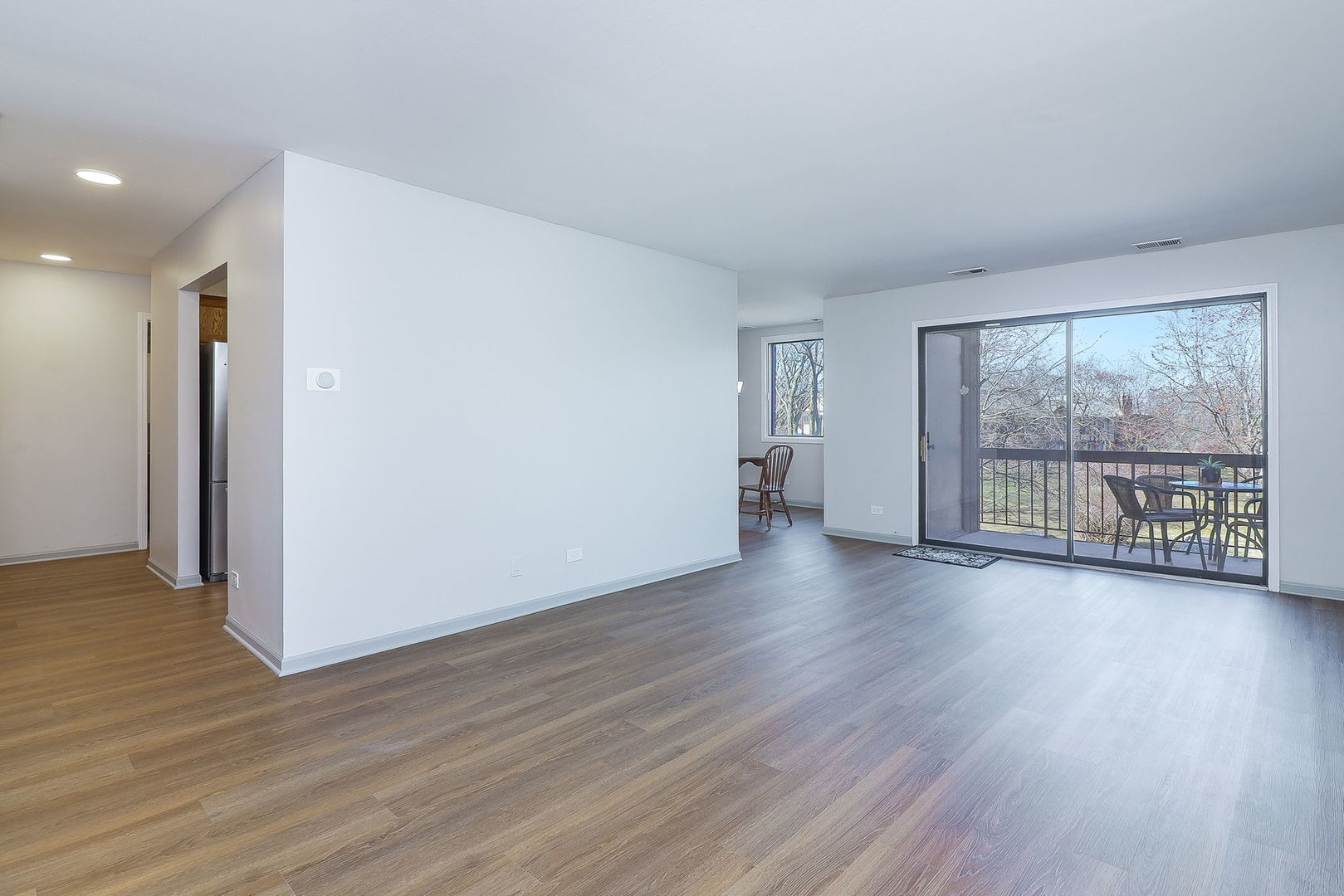 440 Raintree Court, Unit 2D Glen Ellyn, IL 60137 - Photo 4 of 23 an empty room with wooden floor and windows