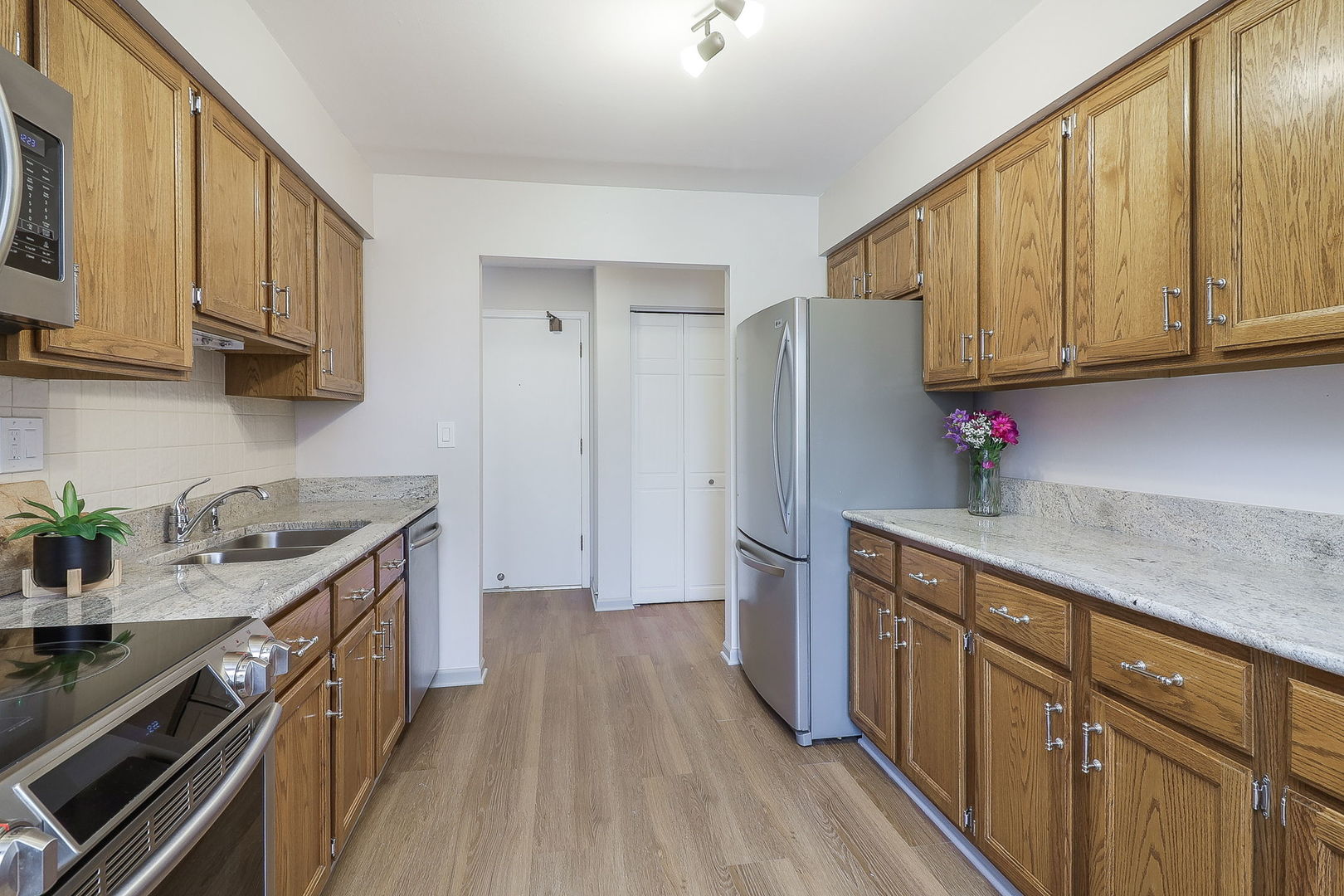 440 Raintree Court, Unit 2D Glen Ellyn, IL 60137 - Photo 8 of 23 a kitchen with stainless steel appliances granite countertop a sink stove and refrigerator