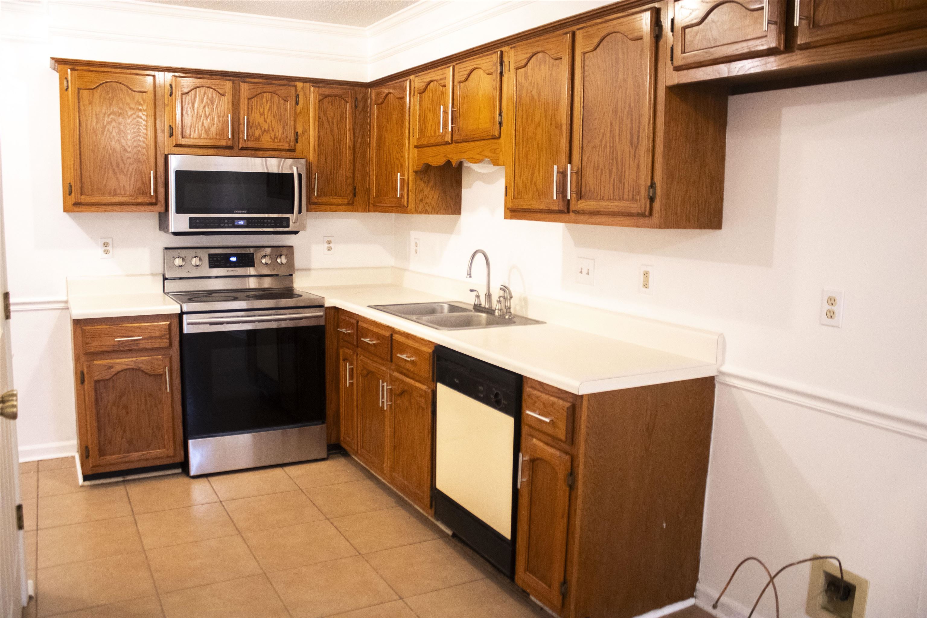 6865 Snyder Road Memphis, TN 38141 - Photo 4 of 10 a kitchen with stainless steel appliances granite countertop a stove top oven a sink dishwasher and a microwave oven with wooden cabinets
