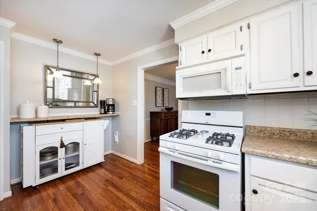 a kitchen with granite countertop cabinets stainless steel appliances and wooden floor