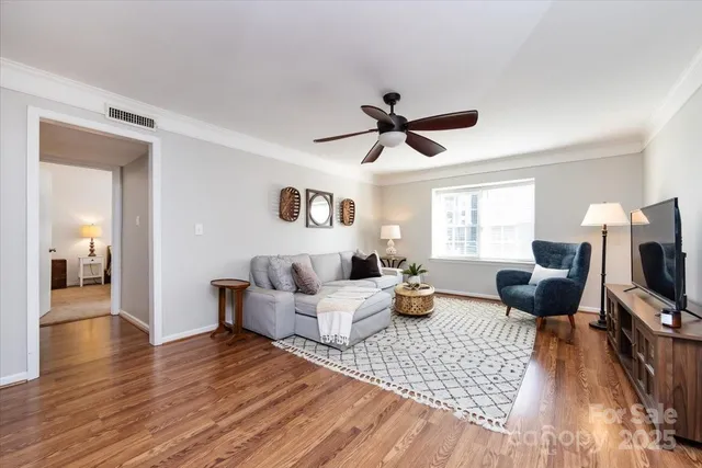 a living room with furniture flat screen tv and wooden floor