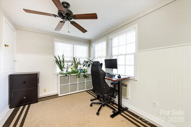 a view of a workspace with furniture and a window