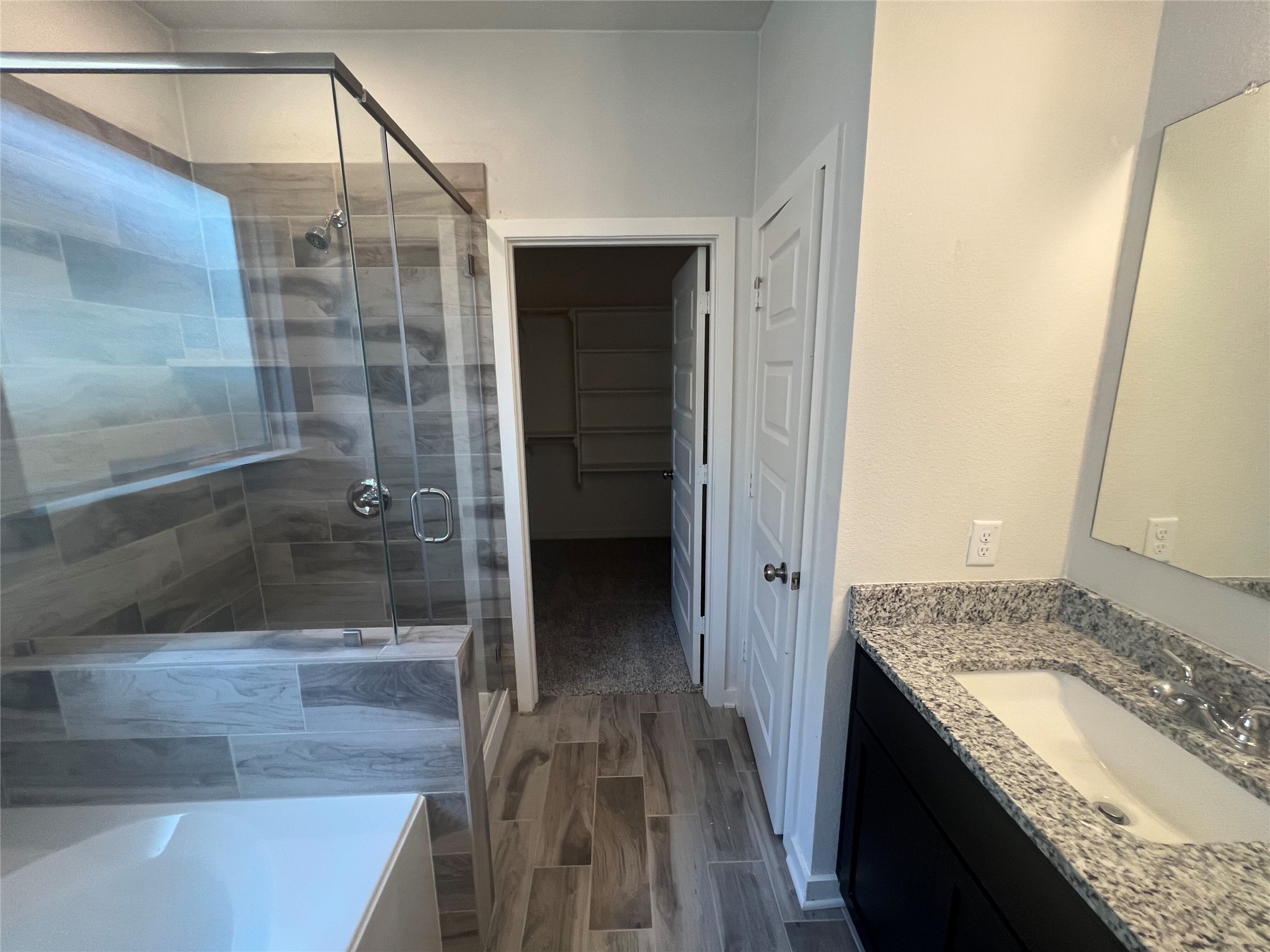 255 Gus Loop Georgetown, TX 78626 - Photo 19 of 24 A well-appointed primary bathroom featuring a spacious shower and a vanity with stone counters.