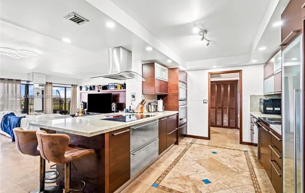 a large kitchen with kitchen island a sink table and chairs