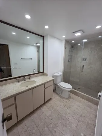 a white toilet sitting next to a bath tub and a shower