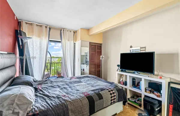 a bedroom with a bed and a flat screen tv