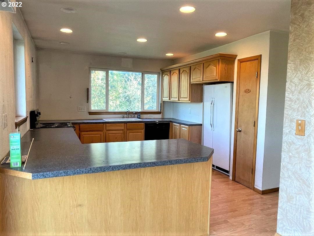 347 Huckleberry Mountain Lane Riddle, OR 97469 - Photo 4 of 32 a large kitchen with stainless steel appliances granite countertop a sink and a refrigerator